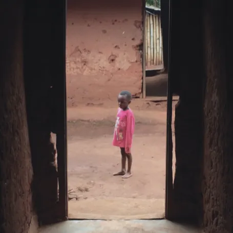 Un enfant vu à travers l’embrasure d’une porte